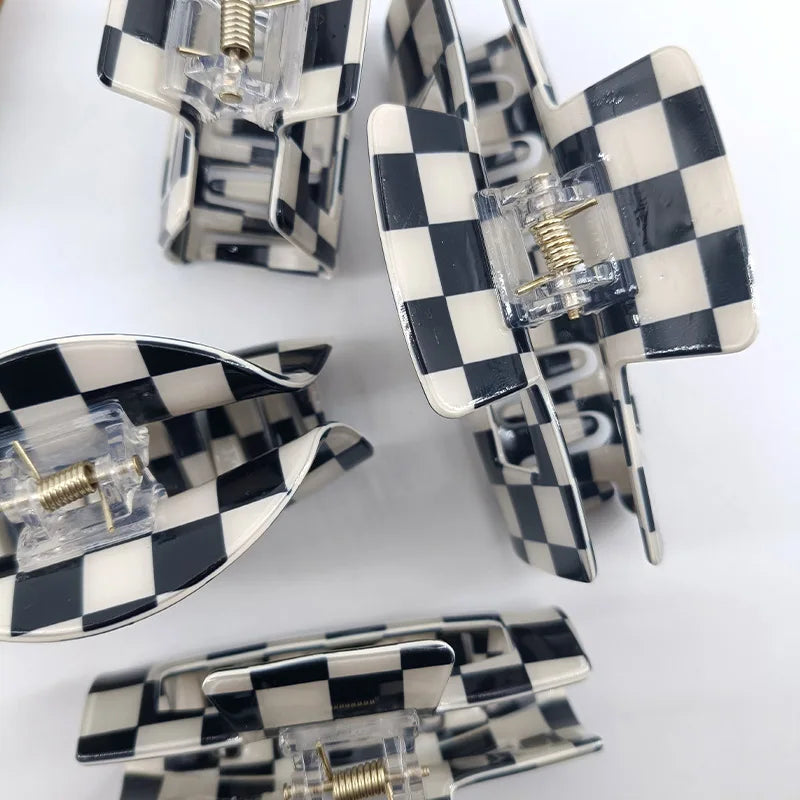 A collection of black and white checkered rectangle hair claw clips displayed on a white background.