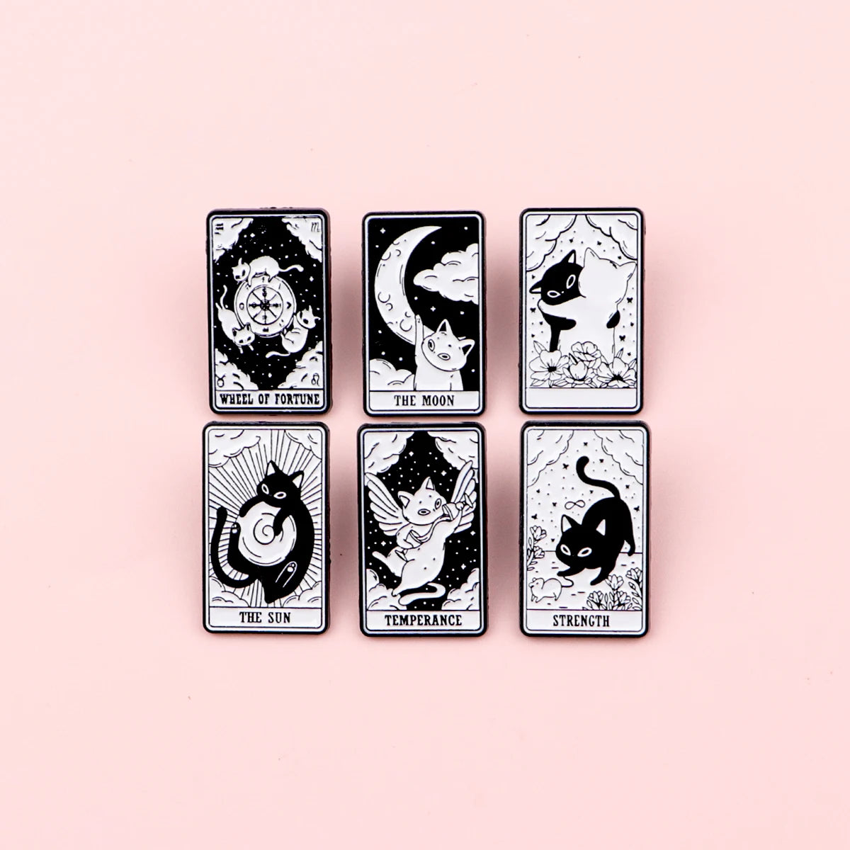 A set of eight black and white tarot-style enamel brooches featuring various animals and symbols like the Wheel of Fortune an