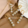 Gold-toned heavy duty pearl safety pins for clothing displayed on a beige background.