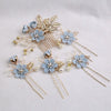 A set of five floral pearl bridal hair accessories featuring light blue flowers and gold accents.