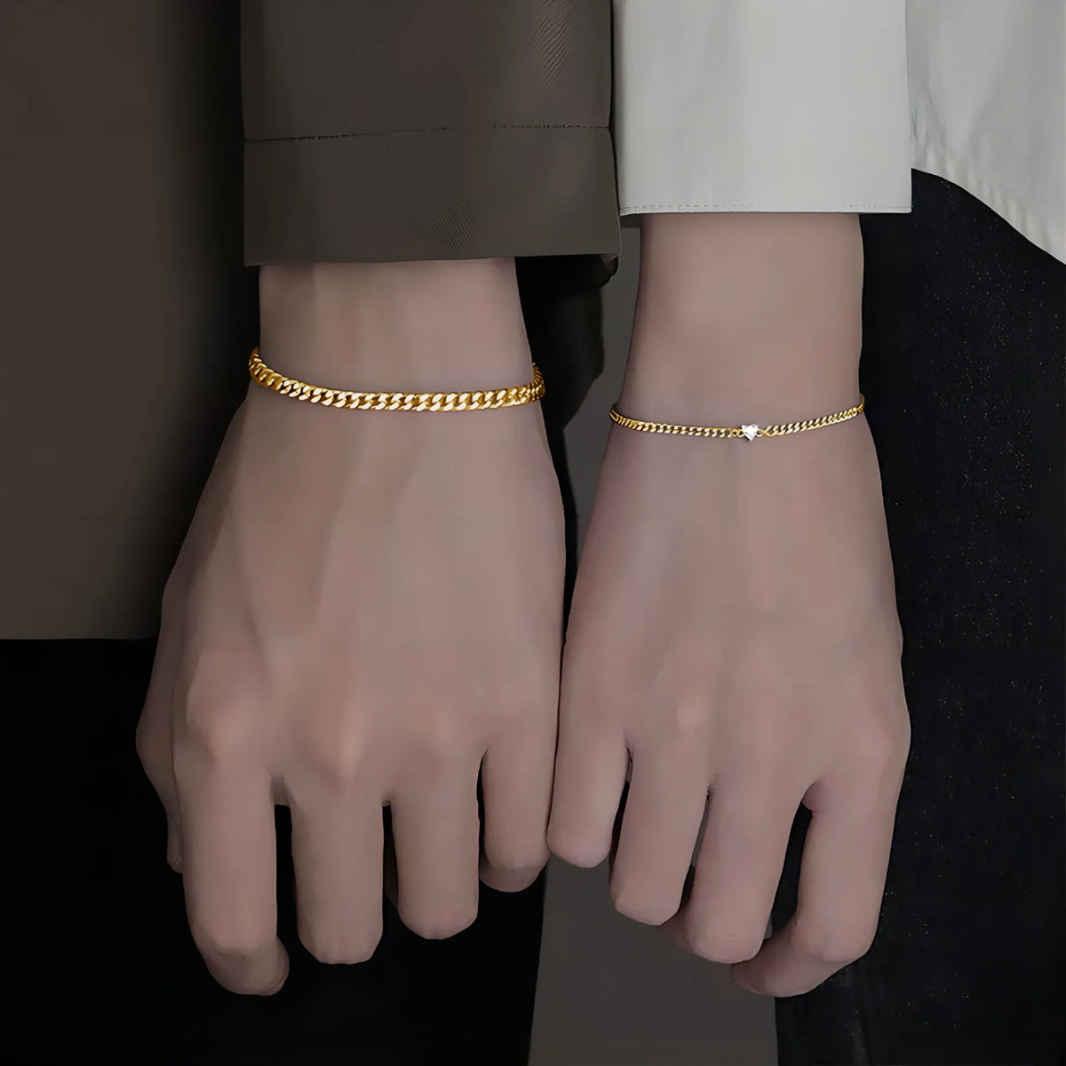 A pair of dainty gold heart link bracelets worn on a person's wrist.