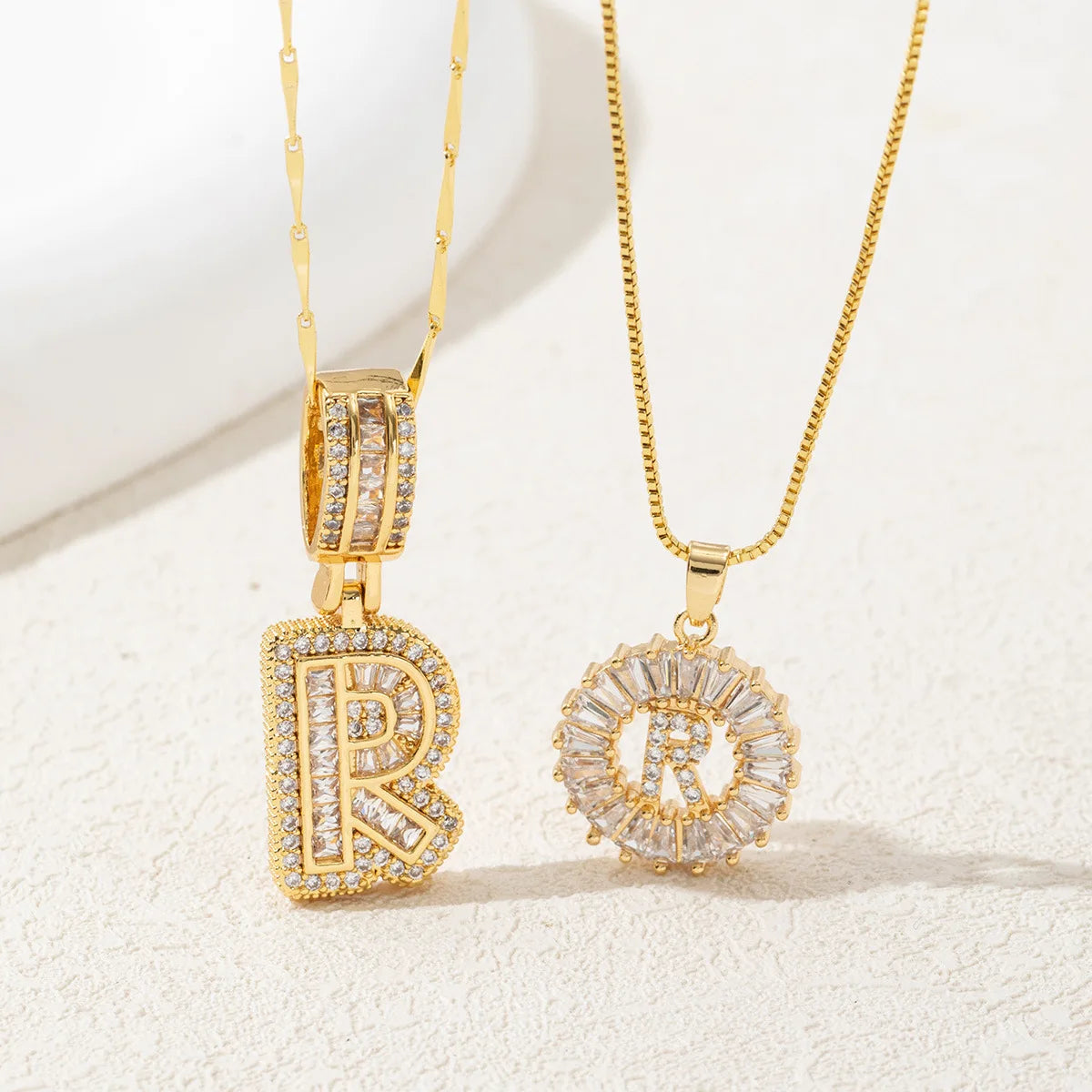 A set of gold-toned initial letter necklaces featuring CZ crystal pendants for a couple.