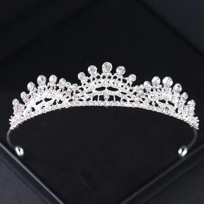 Tiara et couronne en strass cristal brillants sur une surface sombre.