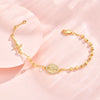 A delicate gold plated rosary bracelet for women displayed on a pink background.