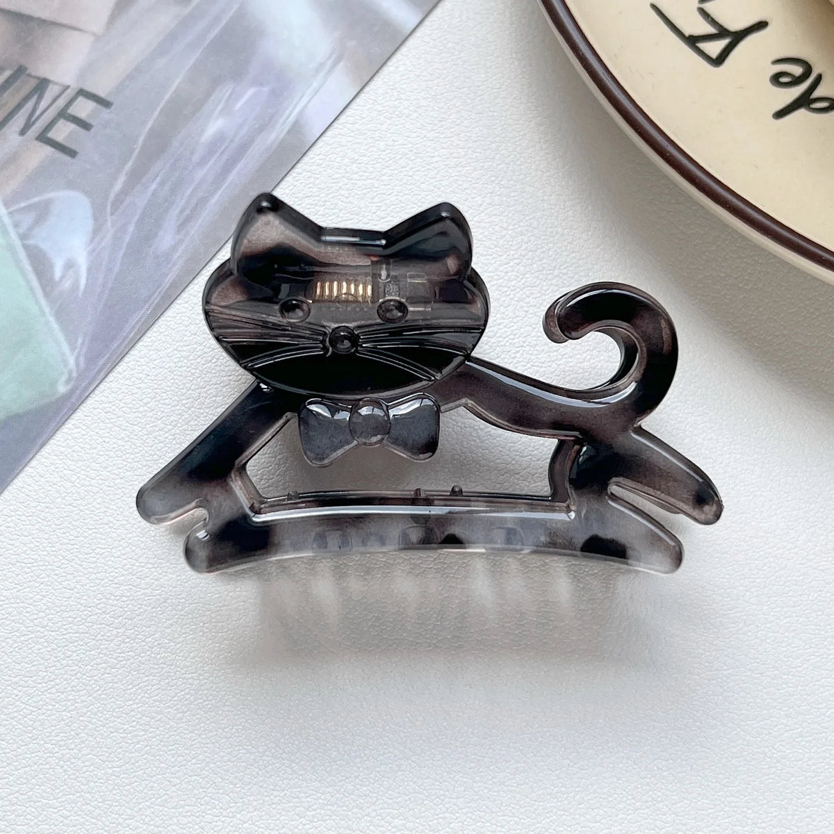 A set of dark gray cat-shaped hair clips made of clear resin