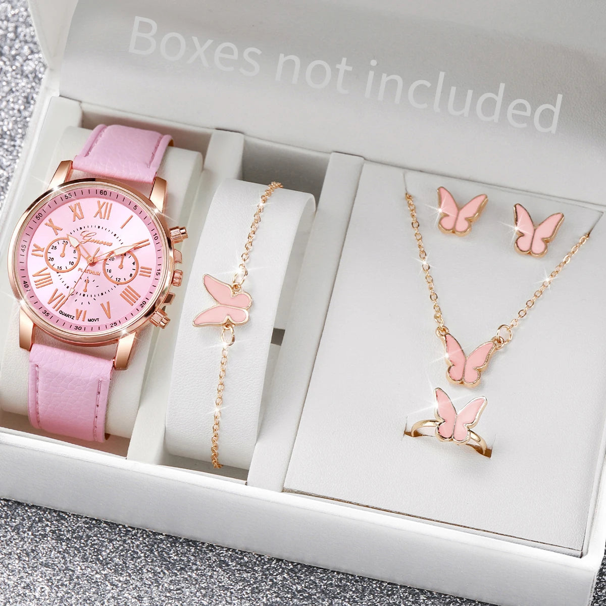 A white box contains a pink quartz wristwatch, a gold chain necklace, and a gold butterfly ring.