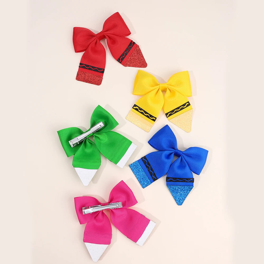 A set of three colorful fabric bows in red, yellow, and blue for hair clips.
