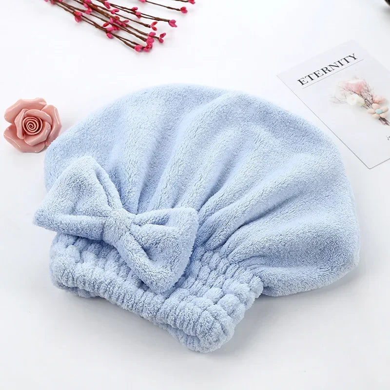 Light blue microfiber hair drying towel with a ruched texture placed on a white surface.
