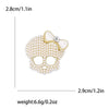 Broche calavera de pedrería delicado con un lazo blanco translúcido.