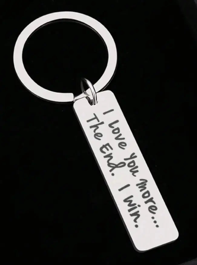 Silver keychain with a loop and a tag engraved with the message I love you more I win