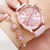 A pink fashion quartz wristwatch with gold accents and a leather strap is shown on a person's wrist.
