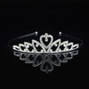 Tiara y corona de princesa de cristal brillante para el cabello, exhibida sobre una superficie negra reflectante.