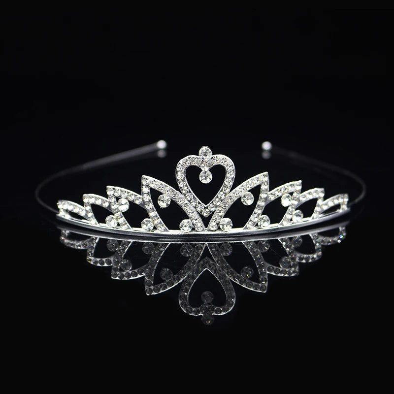 Tiara y corona de princesa de cristal brillante para el cabello, exhibida sobre una superficie negra reflectante.