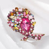 Broche florale en cristal vibrante avec des pierres roses et dorées.
