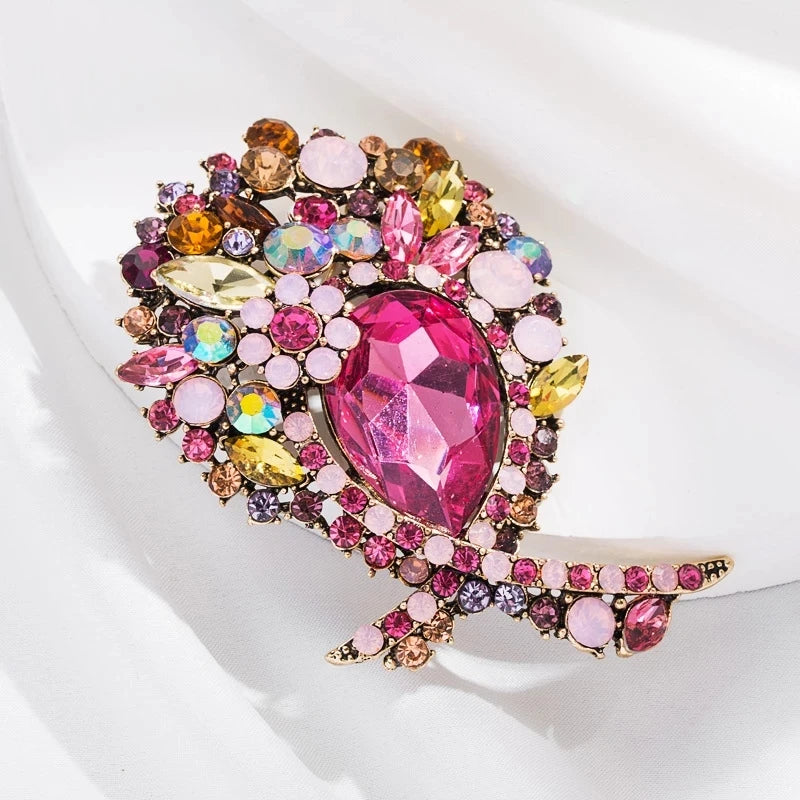 Broche florale en cristal vibrante avec des pierres roses et dorées.