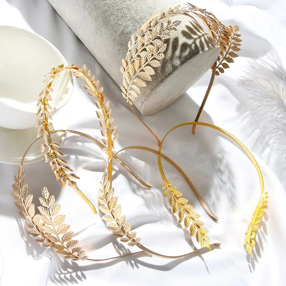 Gold leaf headband for bridal or party decoration resting on a white surface.