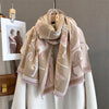 A beige and pink plaid cashmere feel scarf draped around a mannequin.