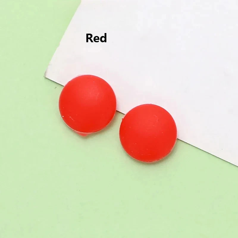 Two red silicone eyeglass grips placed on a white background.