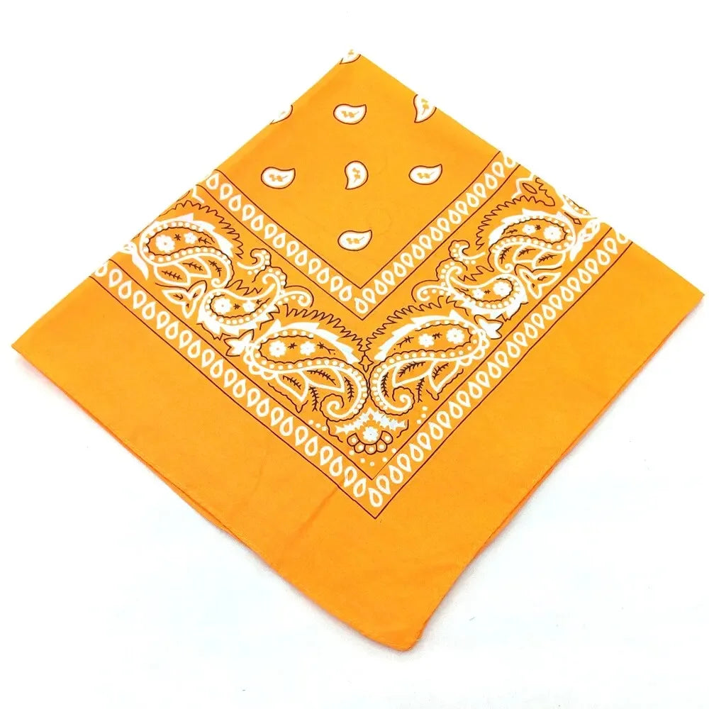 Orange fabric bandana featuring white paisley and geometric patterns