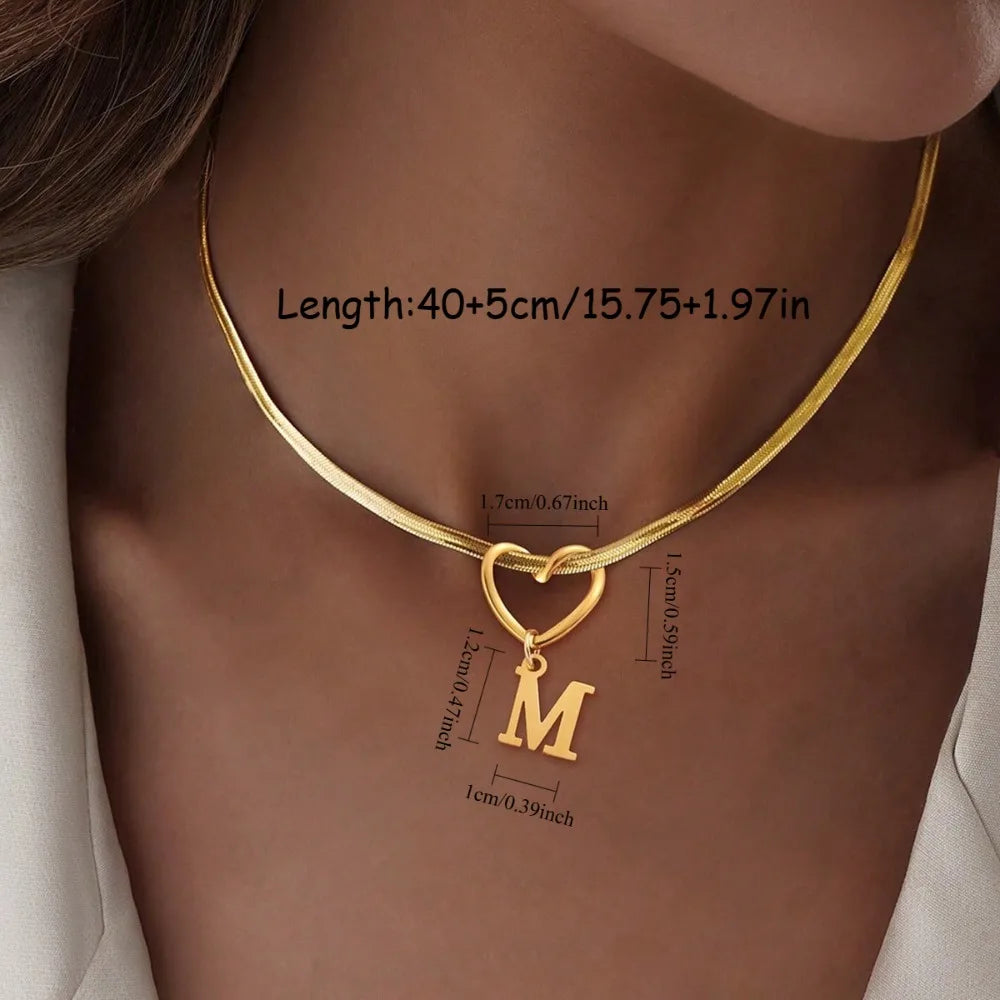 Goldplattierte Initialherz-Kette mit einem M-Anhänger, um den Hals getragen.