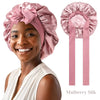 A woman wearing a pink Mulberry Silk sleep bonnet for curly hair, shown alongside the product.
