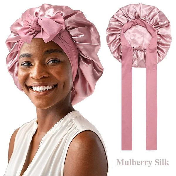 A woman wearing a pink Mulberry Silk sleep bonnet for curly hair, shown alongside the product.