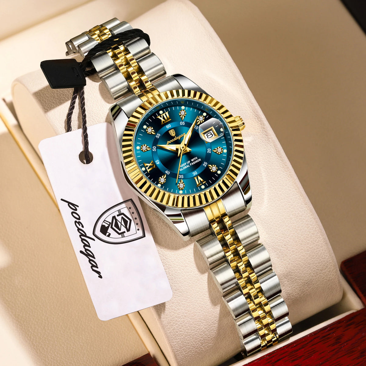 A silver and gold watch set with luminous hands and date display resting on a light-colored surface.