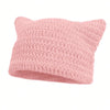 A light pink crocheted beanie hat with cat ear designs.