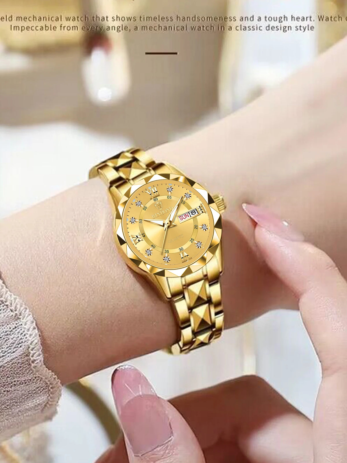 A close-up of a gold-toned mechanical watch with a sunburst dial and diamond accents worn on a wrist.