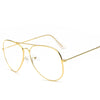 Lunettes avec monture dorée rétro et verres clairs sur fond blanc