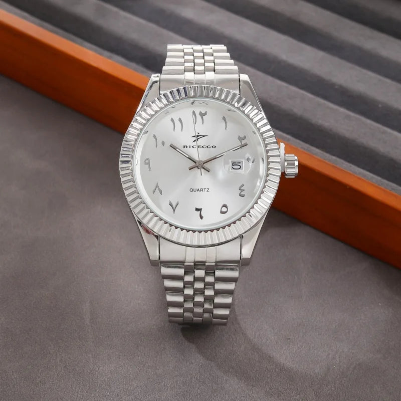 A silver-toned quartz wristwatch with a metal bracelet and Arabic numerals on the dial, resting on a dark surface.