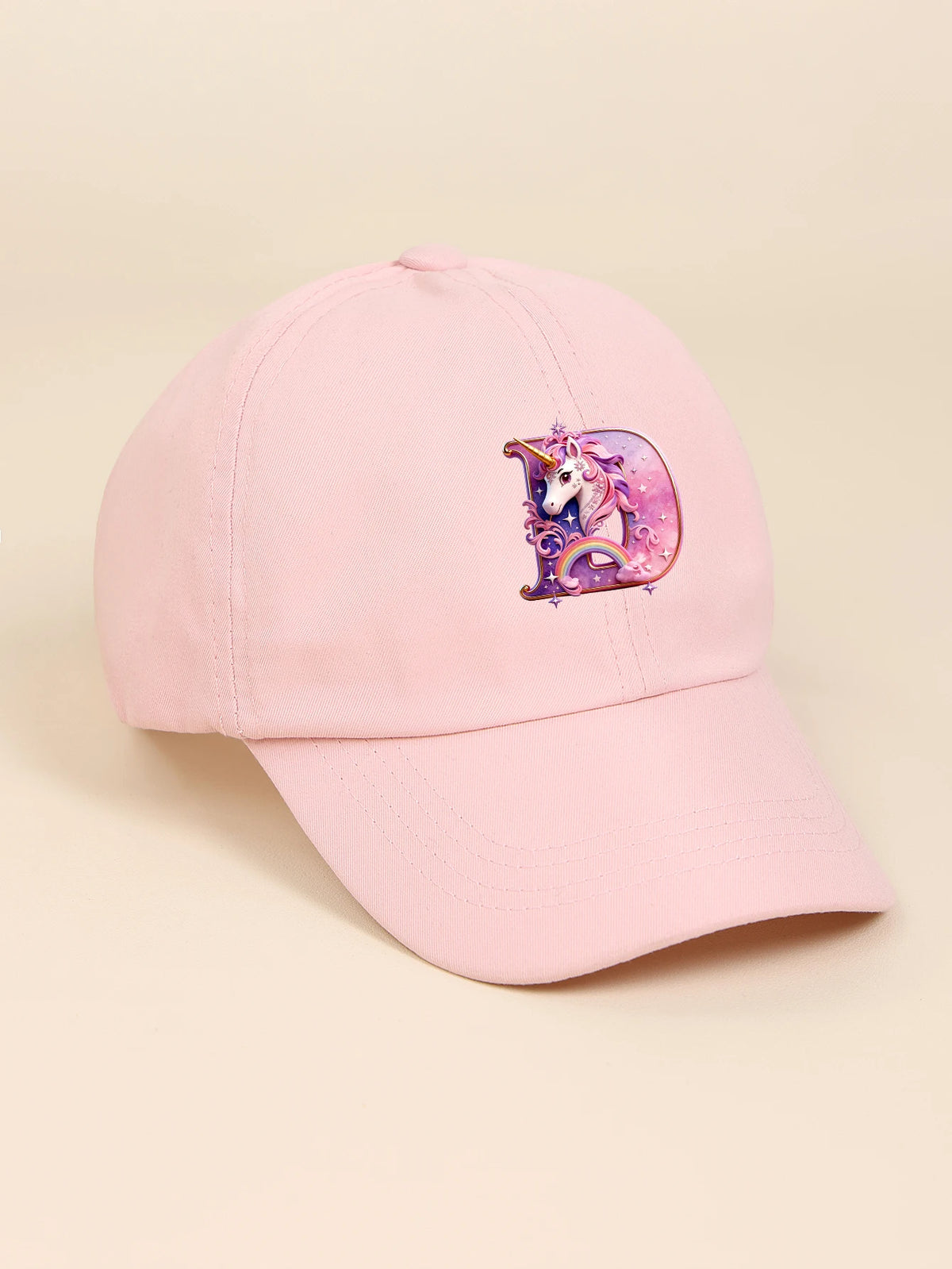 A pink baseball cap featuring a colorful rainbow unicorn design on the front.