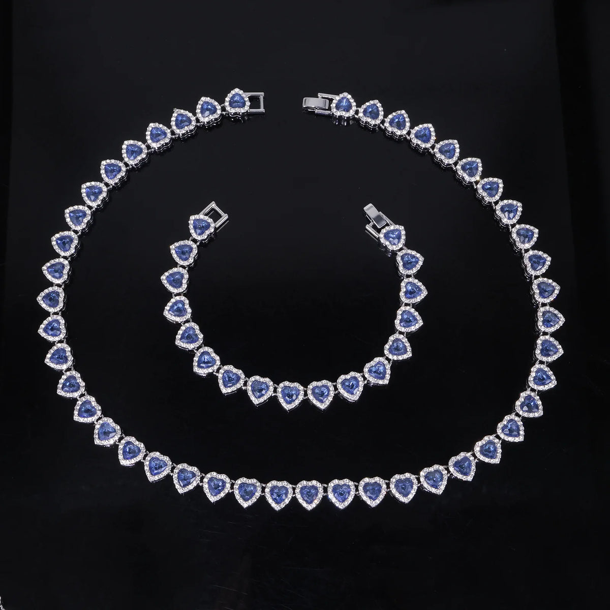 A set of sparkling heart rhinestone necklaces and bracelets displayed on a black background.