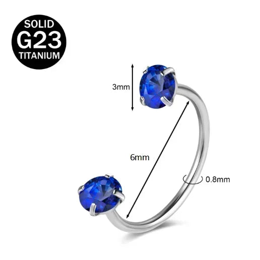 A silver titanium nose ring featuring a round blue crystal gemstone.