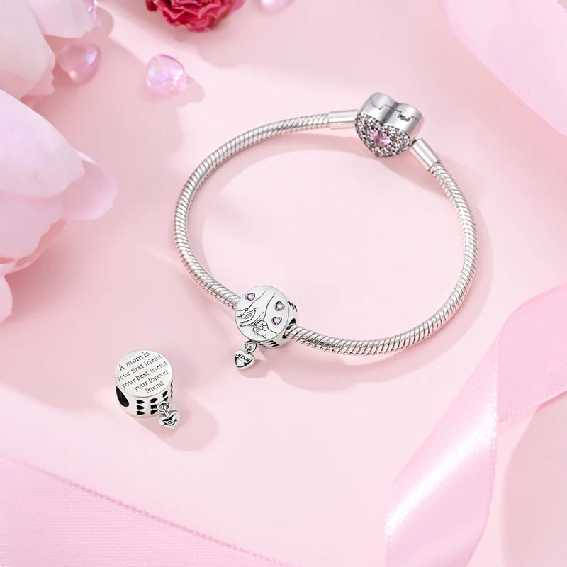 A sterling silver devil's eye charm bracelet with a pink gemstone and a charm featuring a skull.