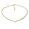 A delicate necklace featuring mother of pearl beads and crystal accents with a U-shaped initial charm.