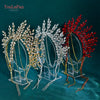 A display of handmade rhinestone bridal crown headbands in gold, silver, and red on clear stands.