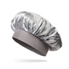 Un bonnet de cheveux en satin de soie argenté est posé sur un fond blanc.