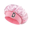 Pink satin hair cap with a black letter D print on the front