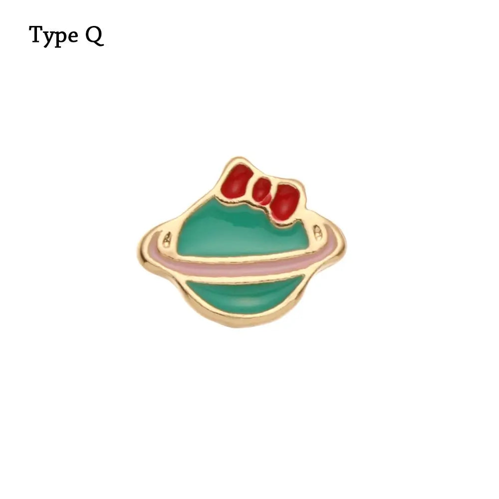 Adorno de pulsera de metal con forma de cara estilizada verde y parte superior roja.