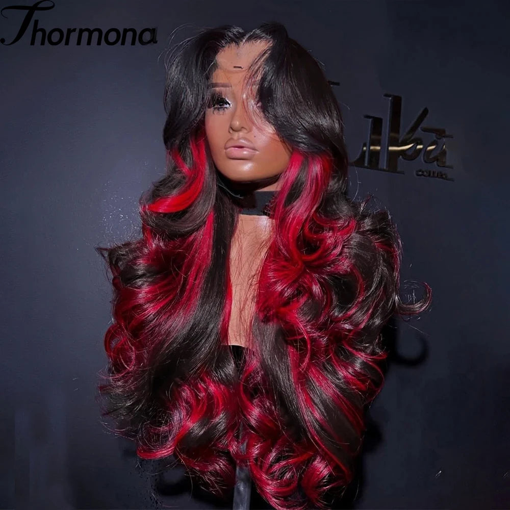 A dark hair wig with vibrant red ombre highlights and wavy texture displayed against a black background.