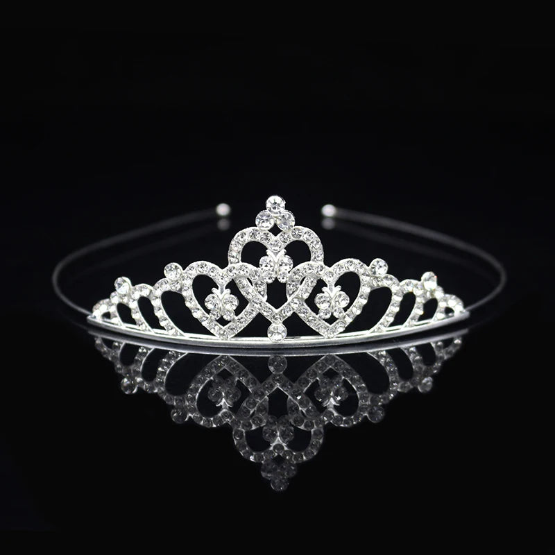 Tiara y corona de princesa de cristal brillante para el cabello, mostrada en una superficie reflectante.