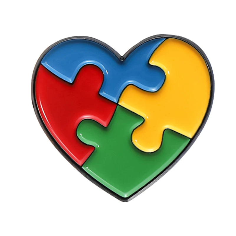 A heart-shaped enamel lapel pin made of five interlocking puzzle pieces in blue, red, yellow, green, and purple.