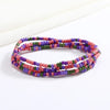 Pulsera hecha de cuentas de colores, tonos rosa, púrpura y verde.