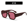 Un par de gafas de sol cuadradas retro de doble puente marrón rojizo con lentes rosas.