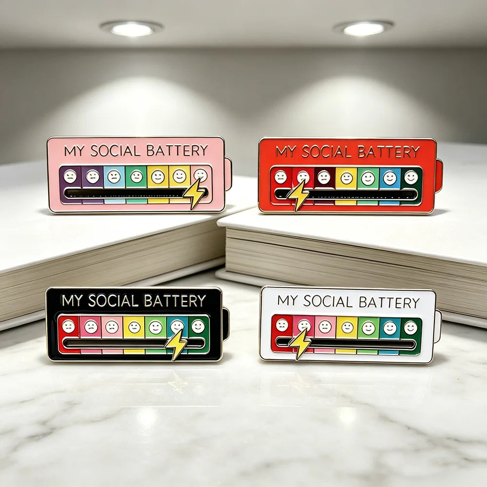 Drei Versionen eines Social-Battery-Messers in Pink, Rot und Schwarz auf weißen Oberflächen.