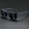 A pair of blue-tinted square sunglasses with black frames resting on a dark surface.