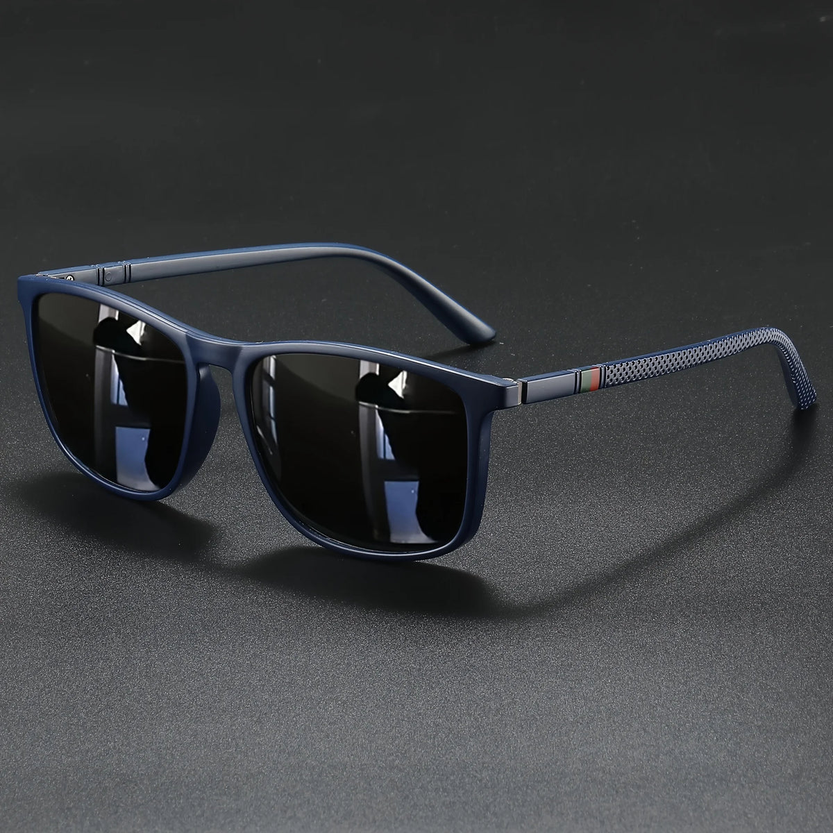 A pair of blue-tinted square sunglasses with black frames resting on a dark surface.