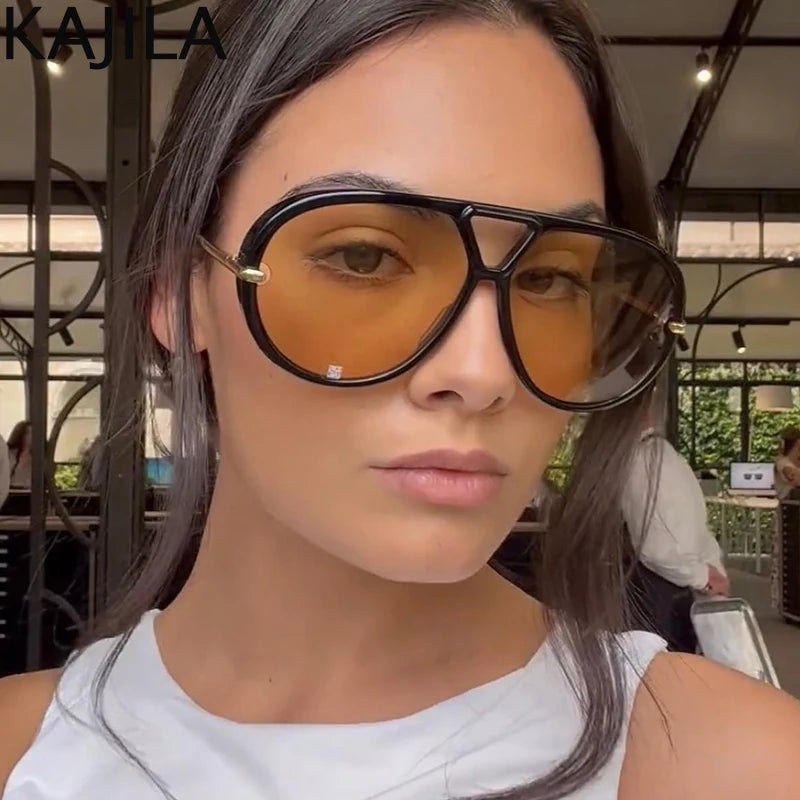 Una mujer usando gafas de piloto vintage grandes con lentes ámbar y montura negra.