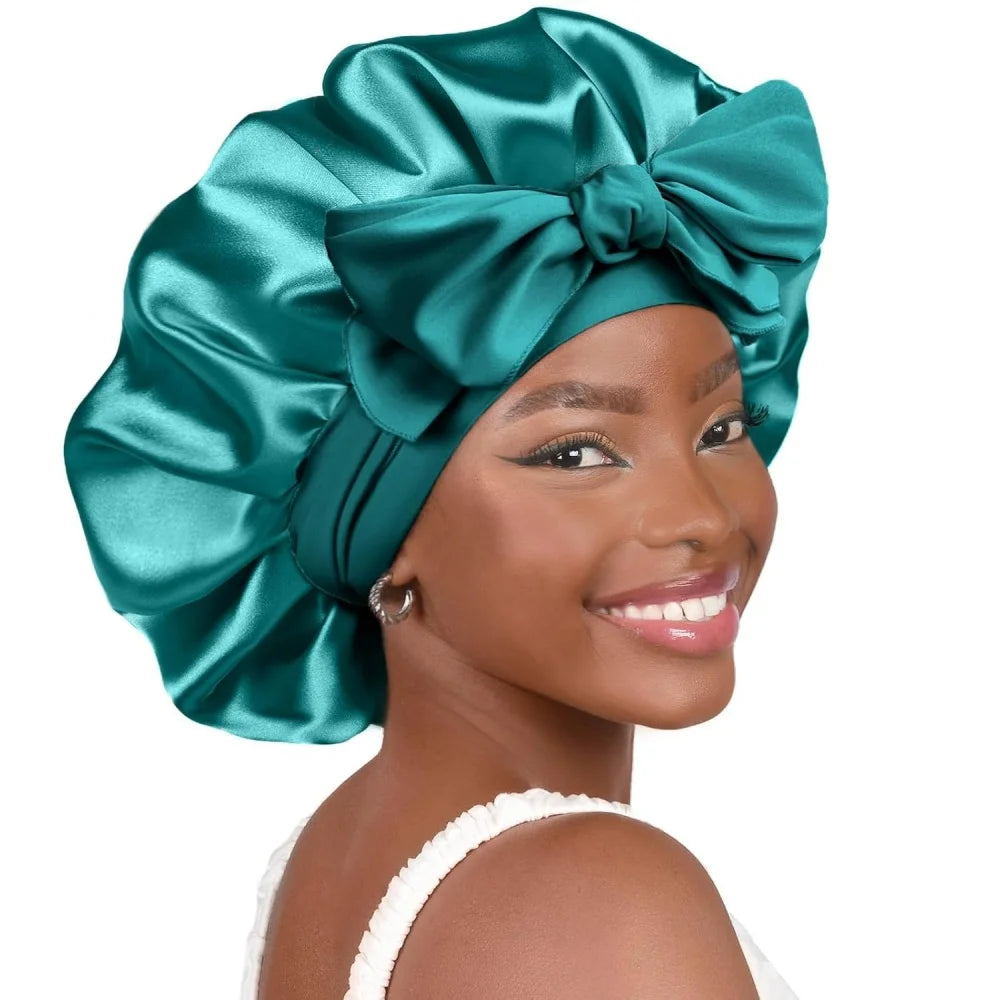 A woman wearing a teal satin sleeping bonnet tied in a large bow.